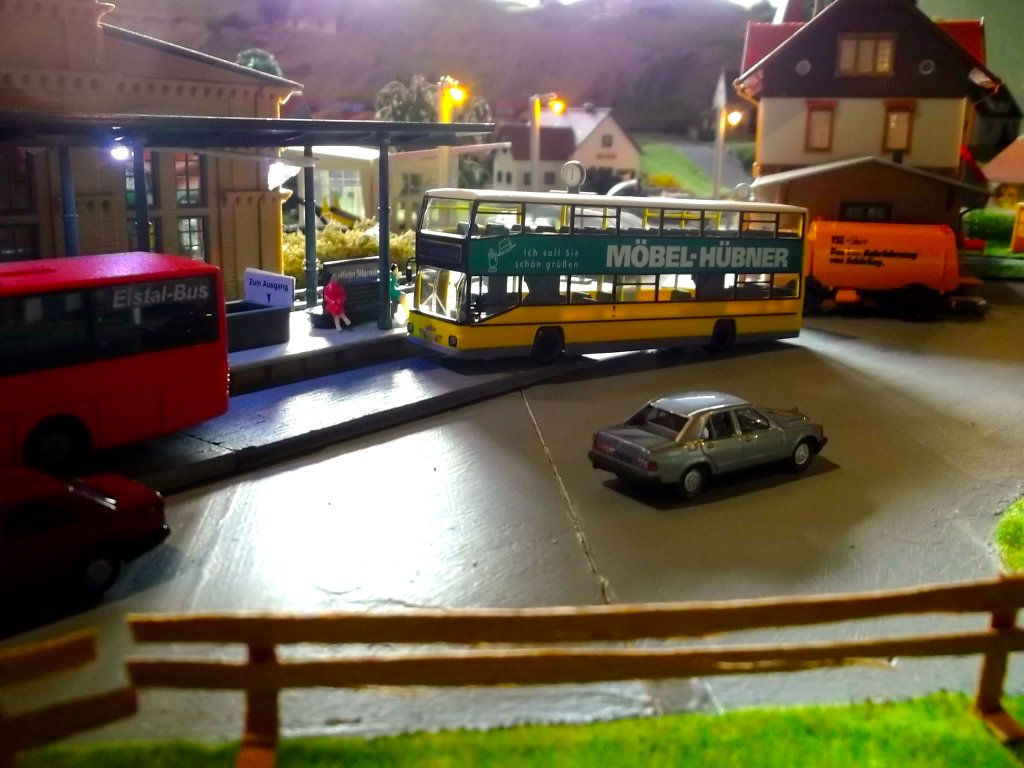 Dieser MAN SD 202 D89 (Hersteller Wiking) im Farbkleid der BVG mit M�bel H�bner-Reklame f�hrt gerade den Bahnhof meiner Modelleisenbahnanlage an.
Im Vordergrund befindet sich ein Mercedes-Benz W201 190E.