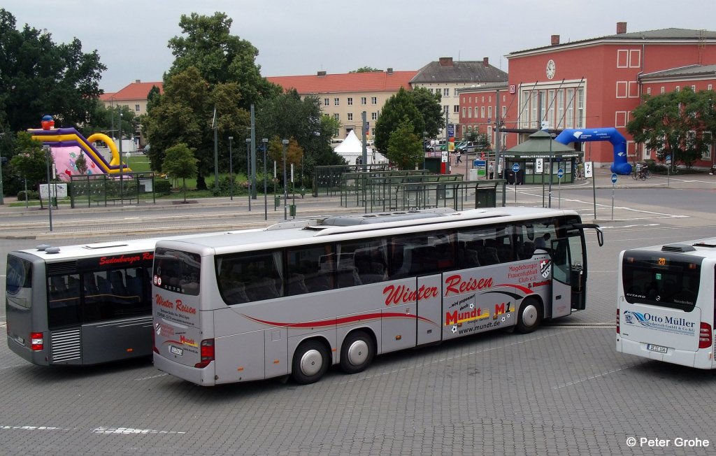 nochmals der Setra S 416 GT-HD von Winter - Reisen aus Egeln mit Werbung f�r Magdeburger Frauenfu�ball Club e.V. und Mundt Energie-Service, fotografiert in Dessau mit Hauptbahnhof im Hintergrund am 07.07.2012