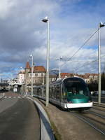 CTS Tram-1015 (Eurotram) unterwegs auf der Linie B (Baggersee).
 Auf der Eisenbahnbrücke befindet sich der Haltepunkt Krimmeri-Meinau und dahinter grüßt das Straßburger Münster.

2012-12-30 Strasbourg Krimmeri 
